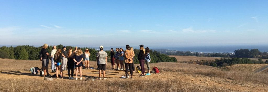 A class circles up in the great meadow above the Monterey bay
